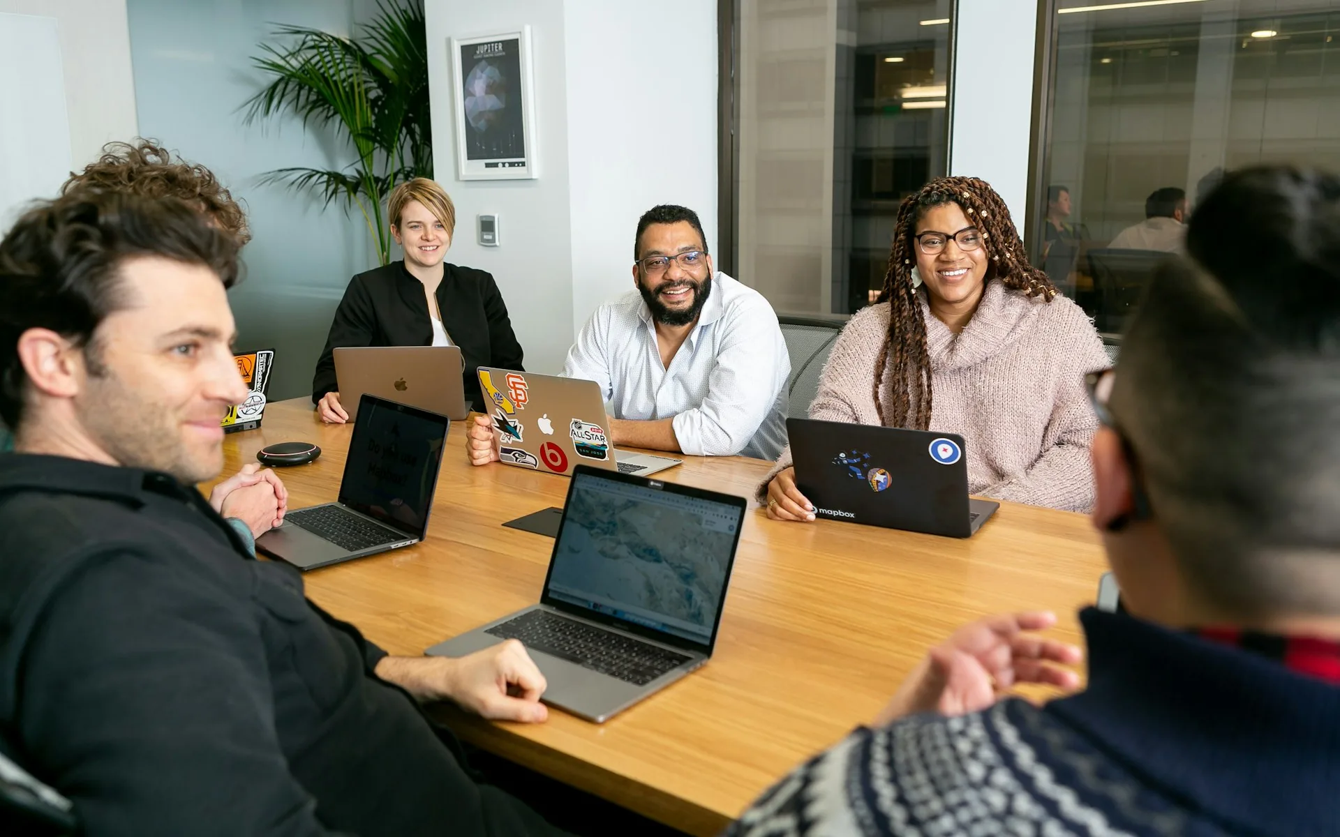 A team of professionals on laptops listening in a business meeting, representing AI automation for businesses